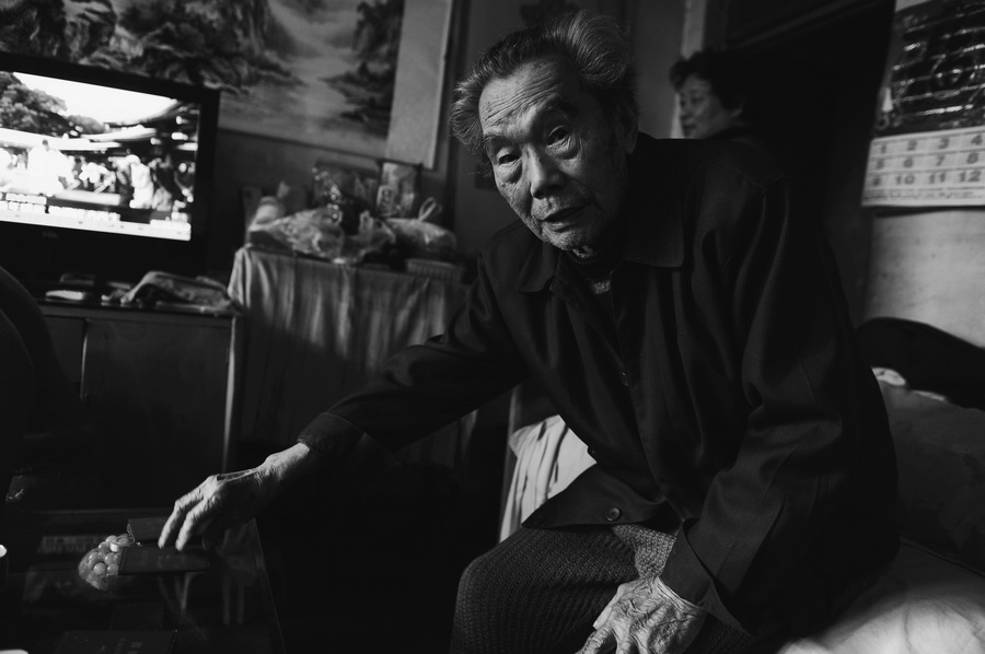 6、抗战老兵何汉松用自己的证件摆在桌子上给志愿者讲述常德战役的战场形势。此役中国士.jpg