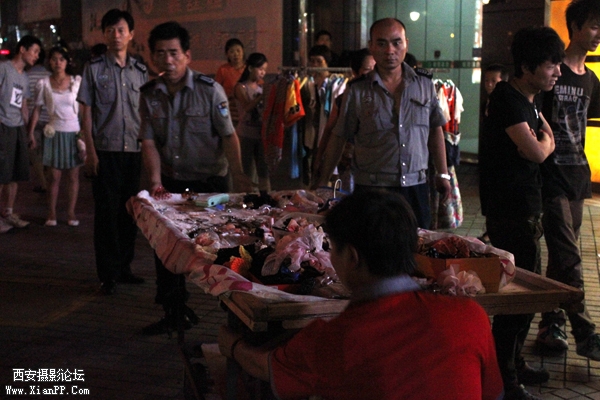 好心城管帮小贩抬被砸倒在地的商品.JPG