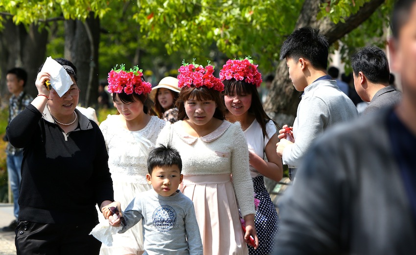 8三位可爱的姑娘头戴花环走在西湖边上。.JPG